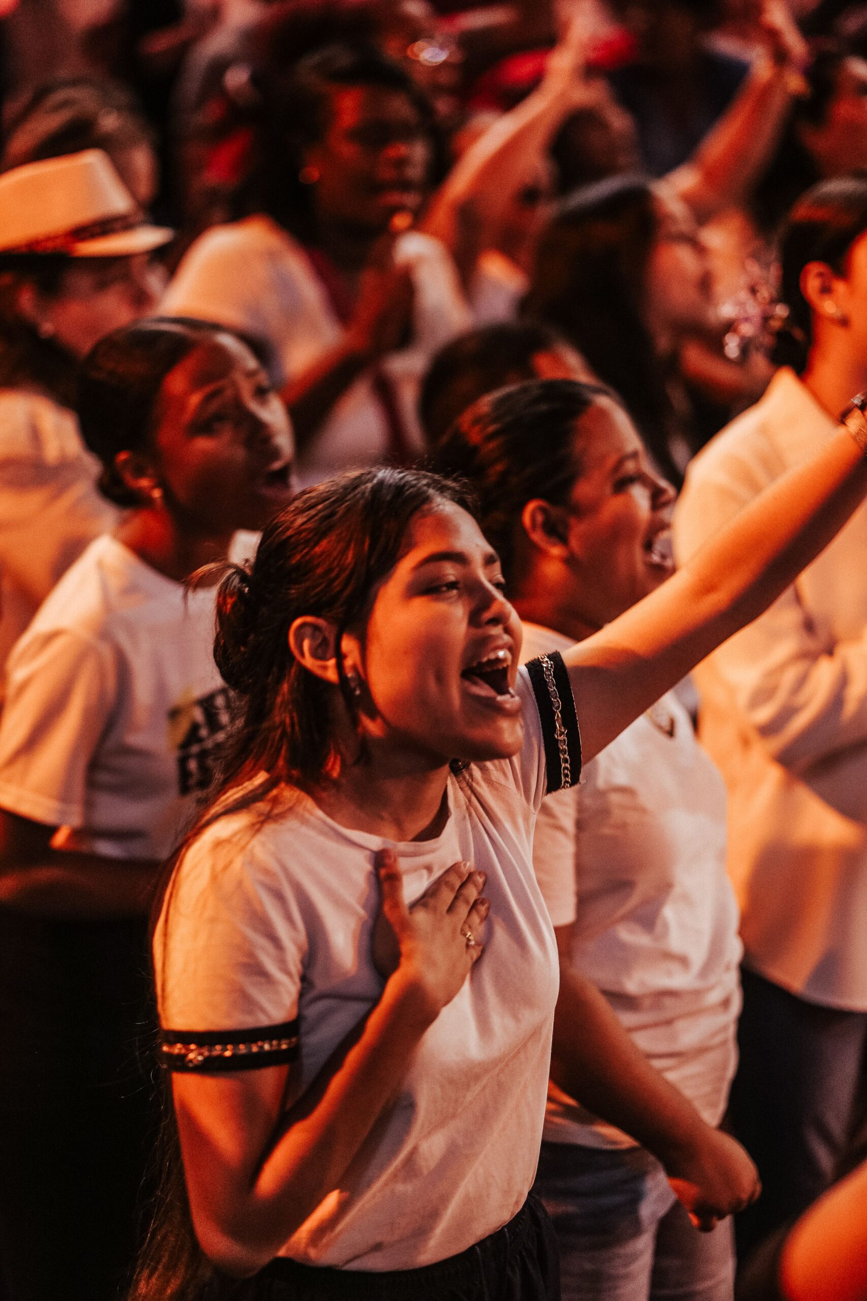 A diverse group of young women passionately participating in a lively worship event.