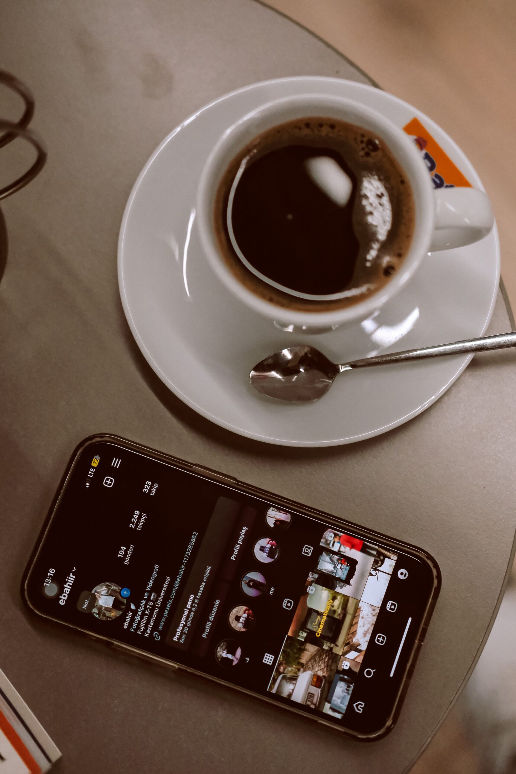 Top view of a cup of espresso with a smartphone on a table, perfect for illustrating modern lifestyle concepts.